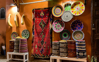 Colorful woven baskets and rugs displayed in Marrakech's Medina market.