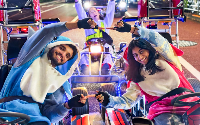 People in costumes enjoying a go-kart ride in Ginza at night.