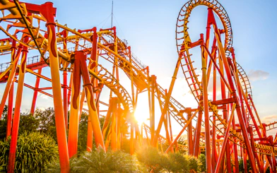 Roller coaster at Beto Carrero World in Florianópolis with sun setting behind.