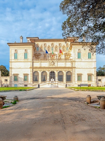 Villa Borghese facade with flags at sunset, Rome, Italy.