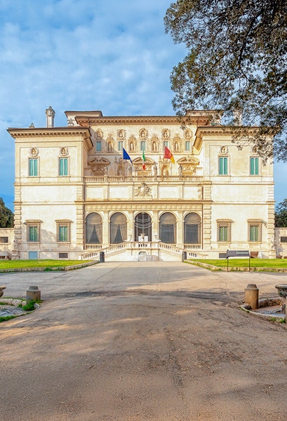 Villa Borghese facade with flags at sunset, Rome, Italy.