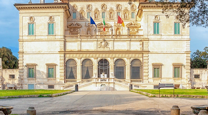 Villa Borghese facade with flags at sunset, Rome, Italy.