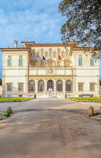 Villa Borghese facade with flags at sunset, Rome, Italy.