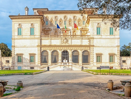 Villa Borghese facade with flags at sunset, Rome, Italy.