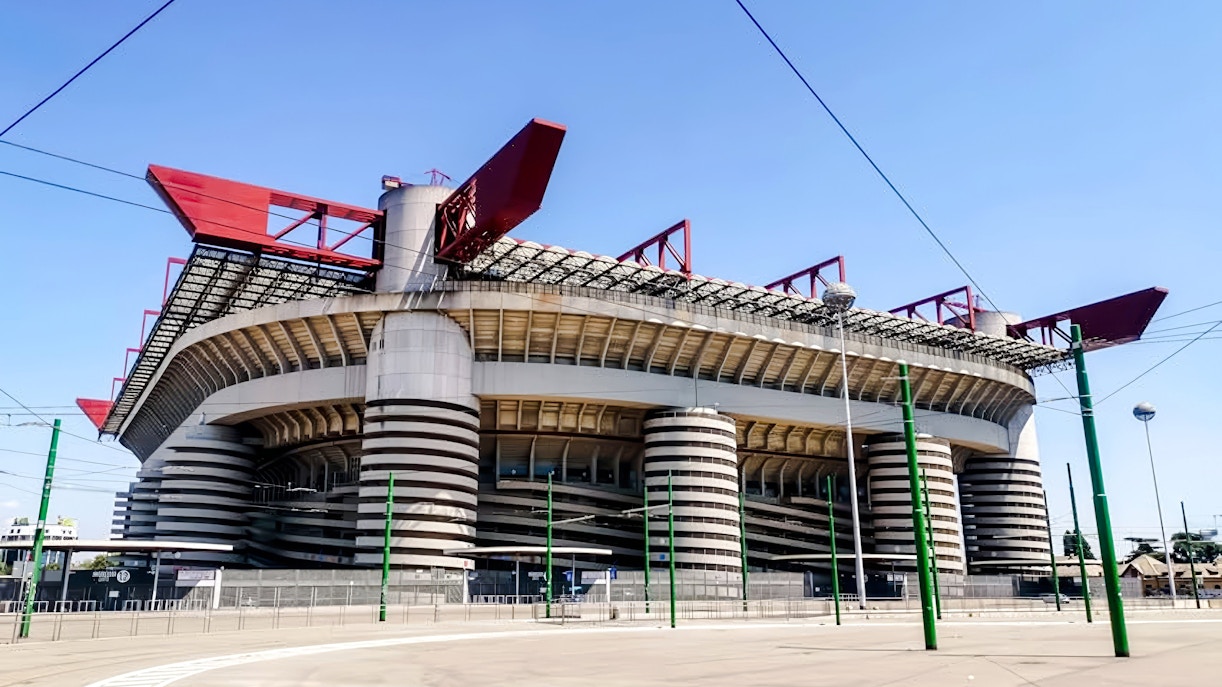 San Siro Stadium exterior view with distinctive red roof structures in Milan, Italy.
