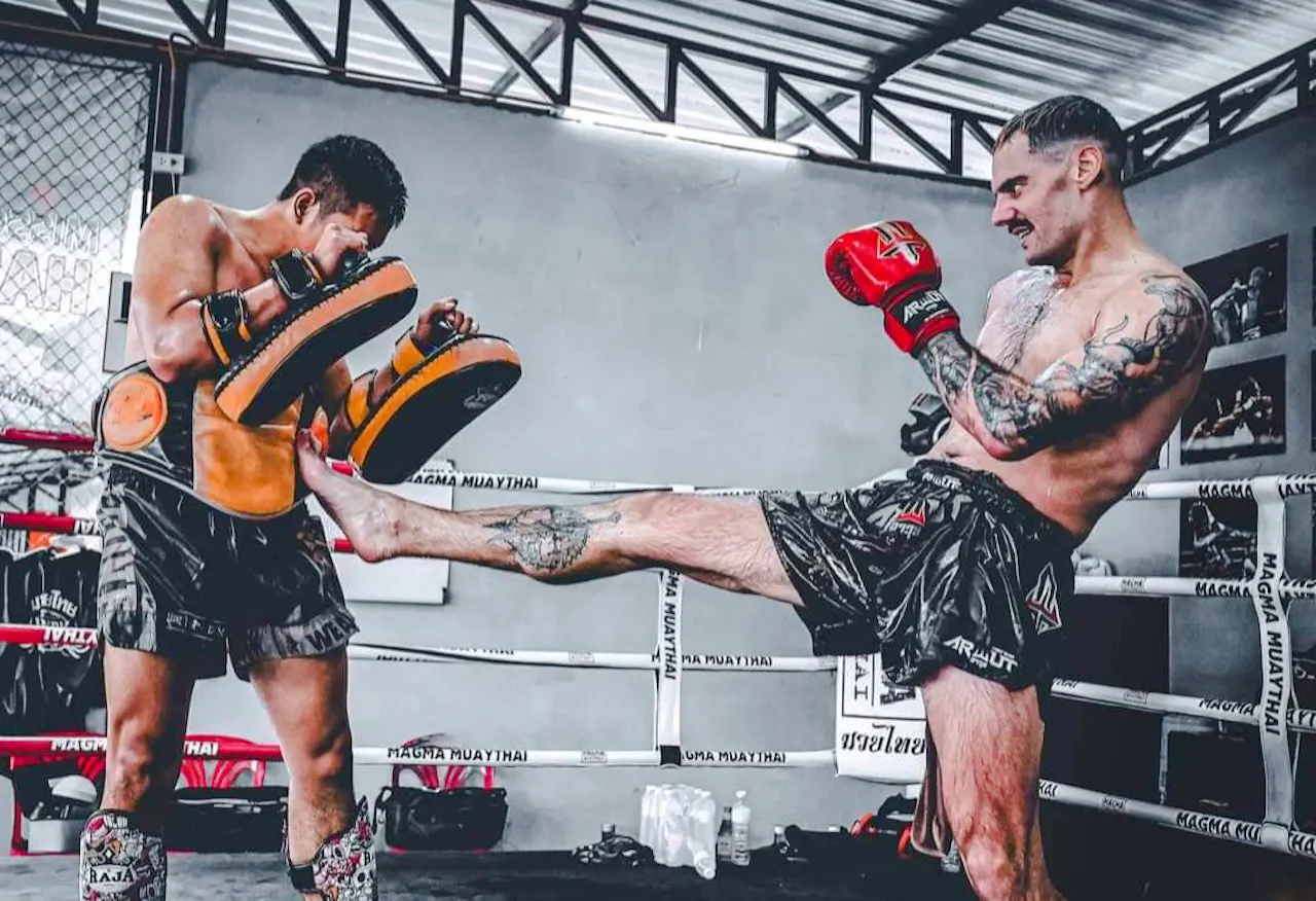 Muay Thai training session with beginners practicing kicks in Pattaya gym.