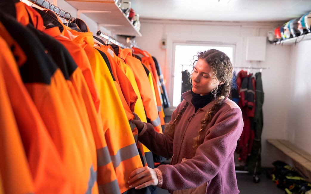 Guest selecting snowmobile gear for Langjökull Glacier adventure.