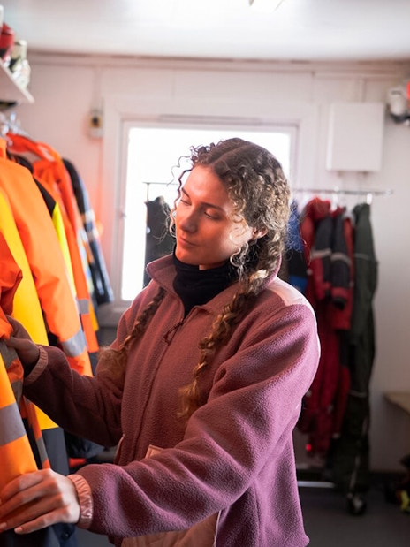 Guest selecting snowmobile gear for Langjökull Glacier adventure.