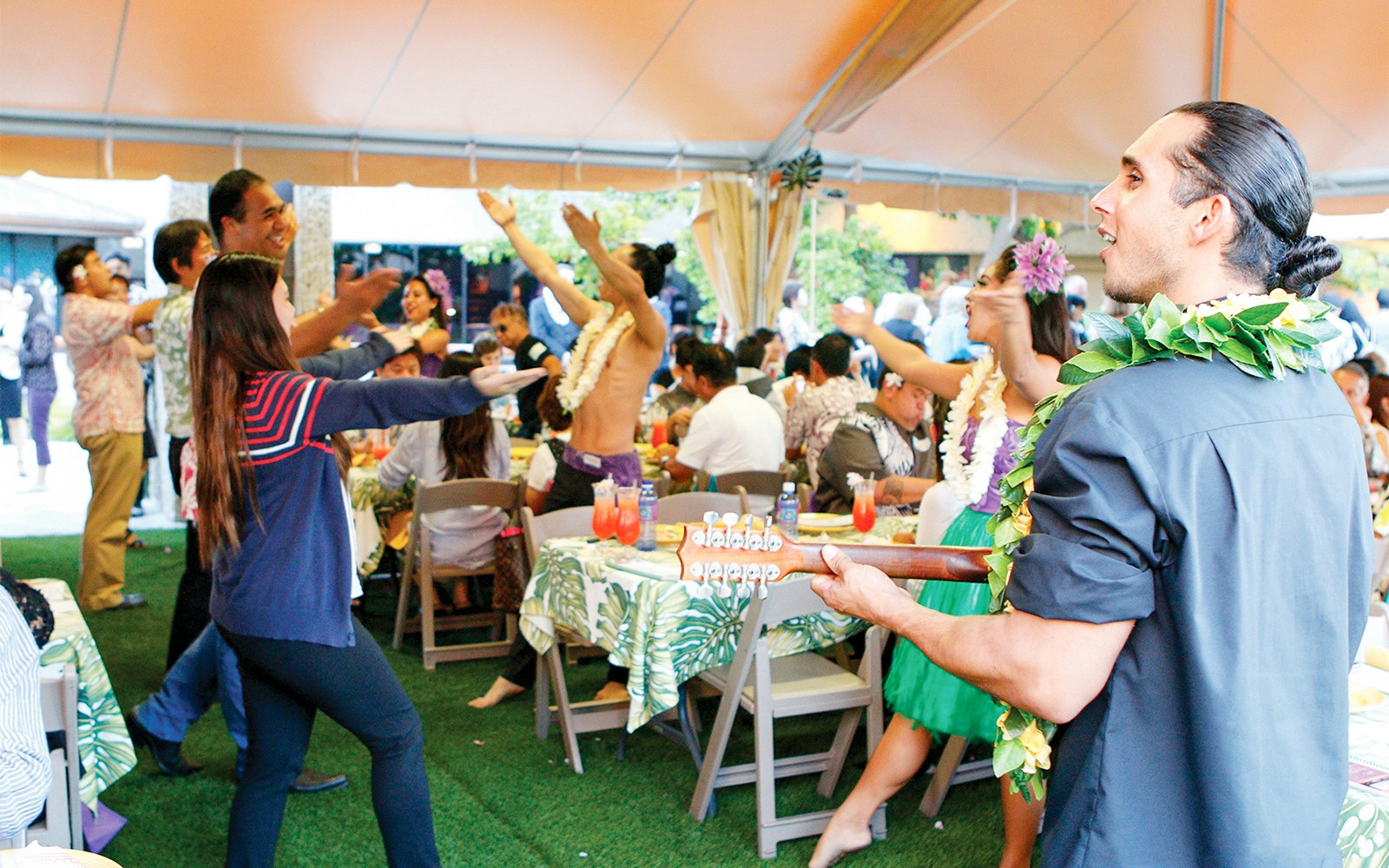 Artists perform with ukulele as guests enjoy Waikiki Luau Buffet before Rock-A-Hula Show.