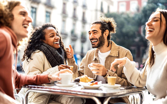 Friends enjoying coffee and pastries at a St. Georg cafe in Hamburg during a culinary tour.