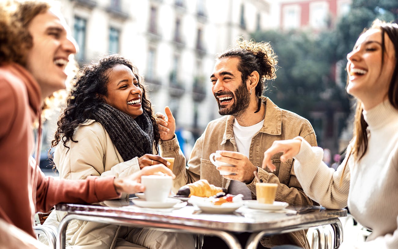 Friends enjoying coffee and pastries at a St. Georg cafe in Hamburg during a culinary tour.