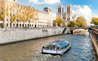 Seine River cruise boat near Notre-Dame Cathedral in Paris.