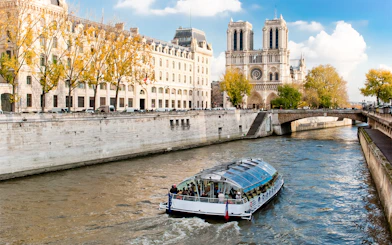 Seine River cruise boat near Notre-Dame Cathedral in Paris.