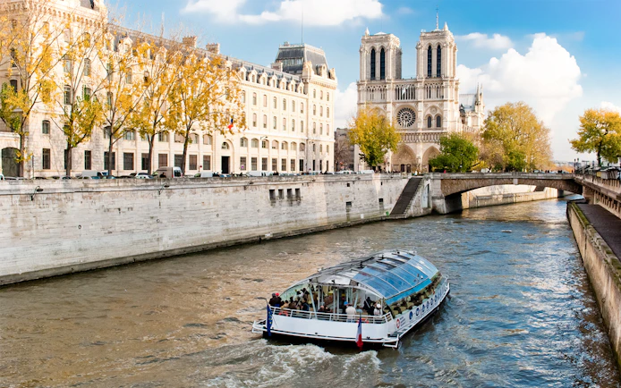 Seine River cruise boat near Notre-Dame Cathedral in Paris.