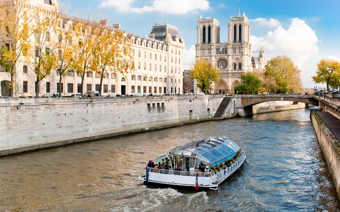 Seine River cruise boat near Notre-Dame Cathedral in Paris.