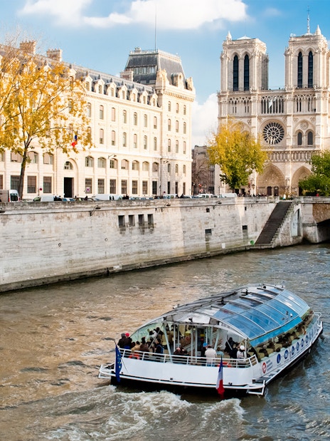 Seine River cruise boat near Notre-Dame Cathedral in Paris.