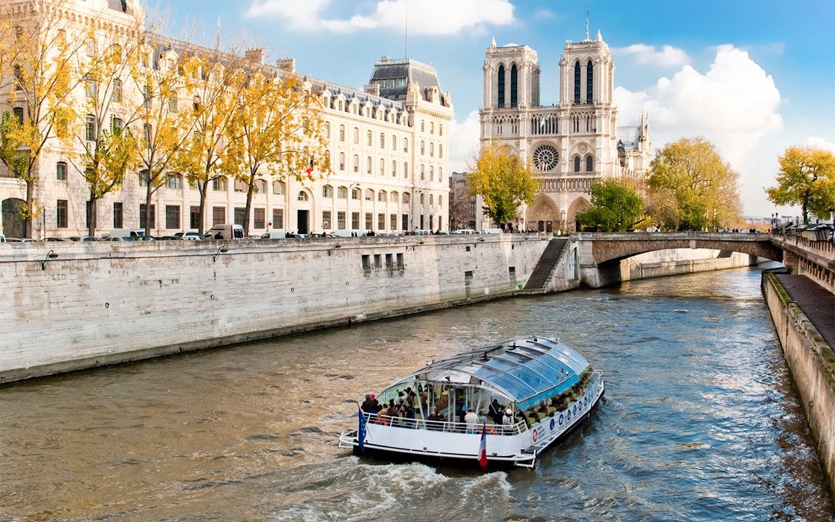 Seine River cruise boat near Notre-Dame Cathedral in Paris.