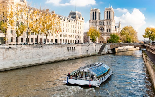 Seine River cruise boat near Notre-Dame Cathedral in Paris.