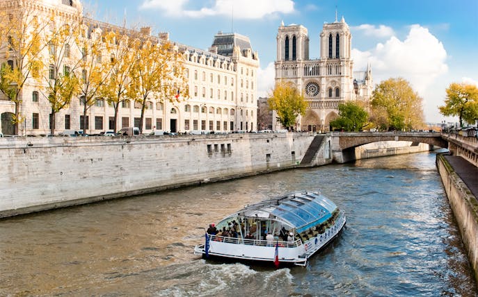 Seine River cruise boat near Notre-Dame Cathedral in Paris.
