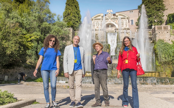 Tour guide with visitors at Tivoli Villa d'Este fountains in Italy.