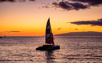 Catamaran sailing at sunset near Oahu during Kaula Kai Sunset Sail.