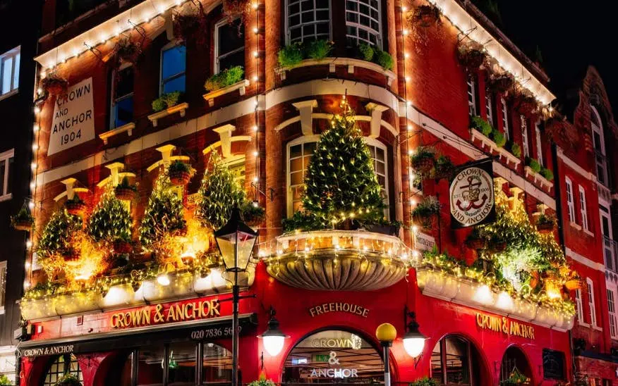 Crown & Anchor pub adorned with Christmas lights in London.