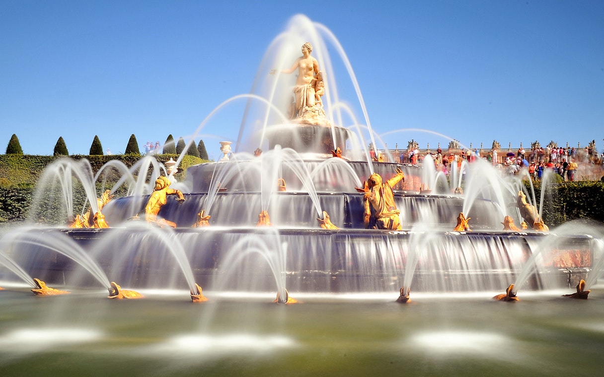 Fountain with golden statues in the Garden of the Palace of Versailles.