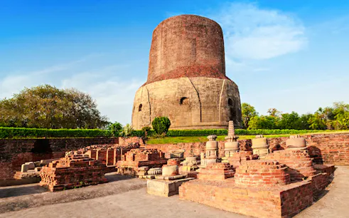 Dhamek Stupa in Sarnath, Varanasi, with ancient brick ruins in the foreground.