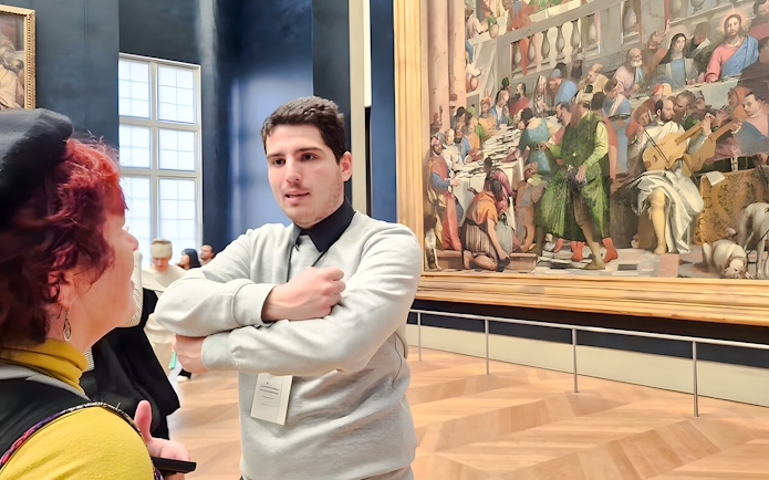 Visitors discussing art inside the Louvre Museum, Paris, France.