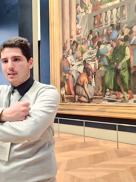 Visitors discussing art inside the Louvre Museum, Paris, France.