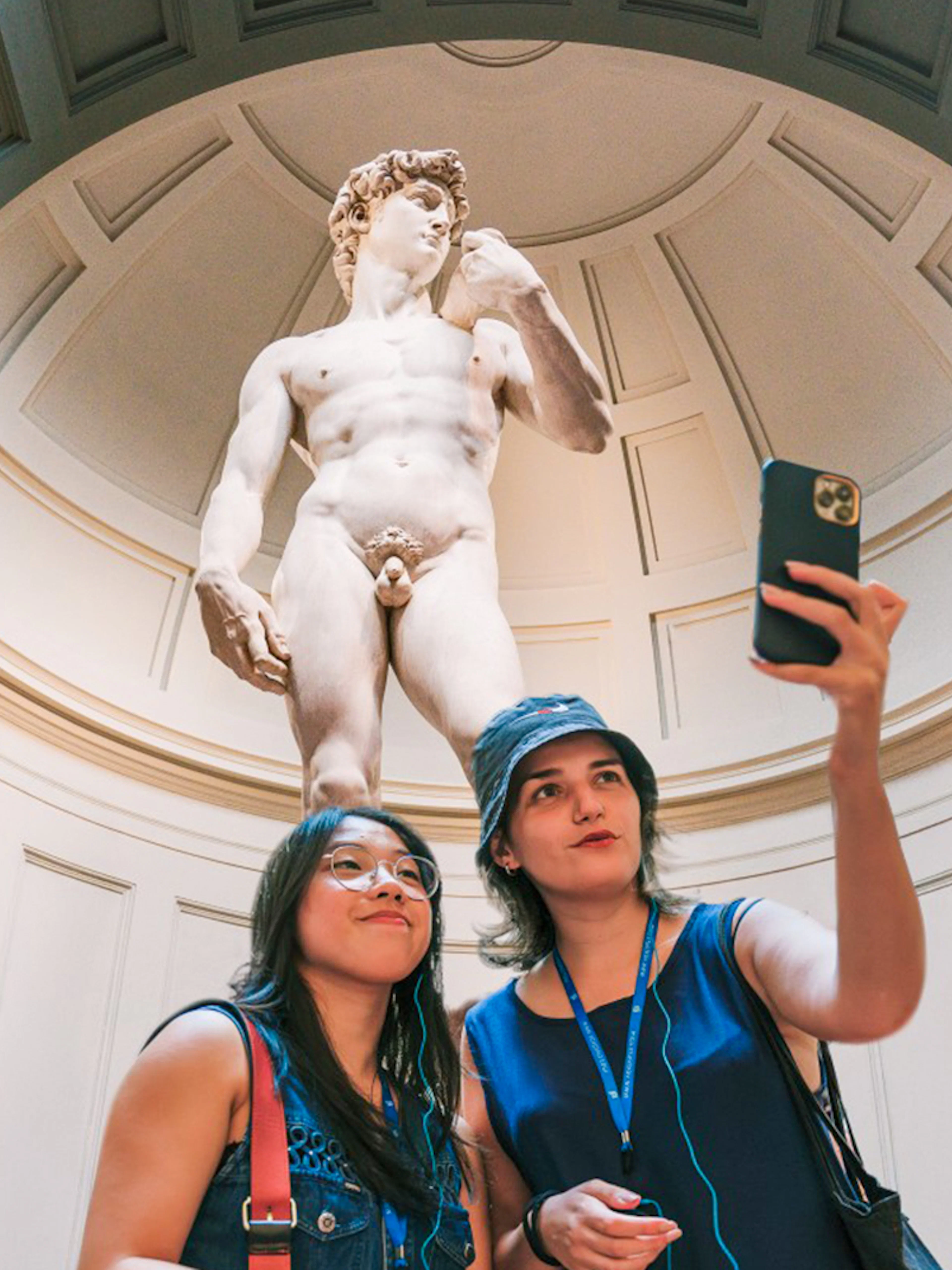 Guests taking a selfie in front of Michelangelo's David in Florence.