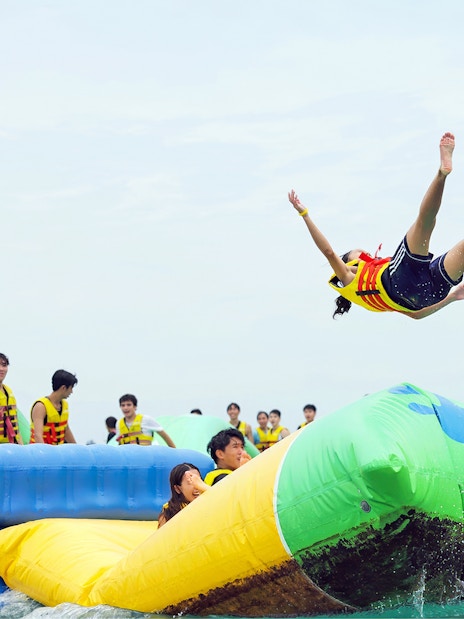 Girl bouncing off inflatable mat at HydroDash water park, Singapore.