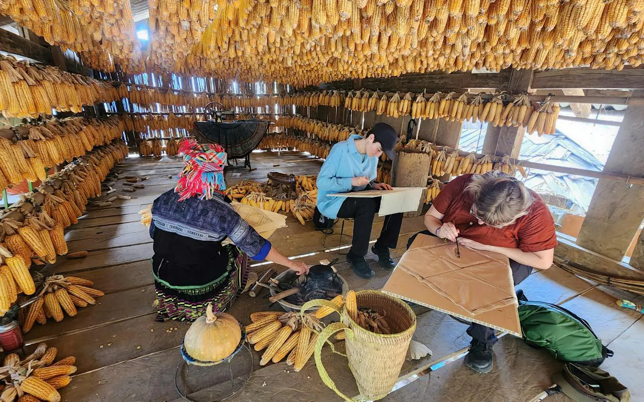 Crafting in a corn-husk lined room during Mu Cang Chai motorbike tour, Sa Pa.