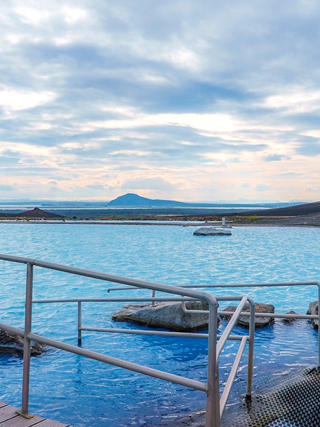 Myvatn Nature Baths with geothermal pool and distant volcanic landscape.