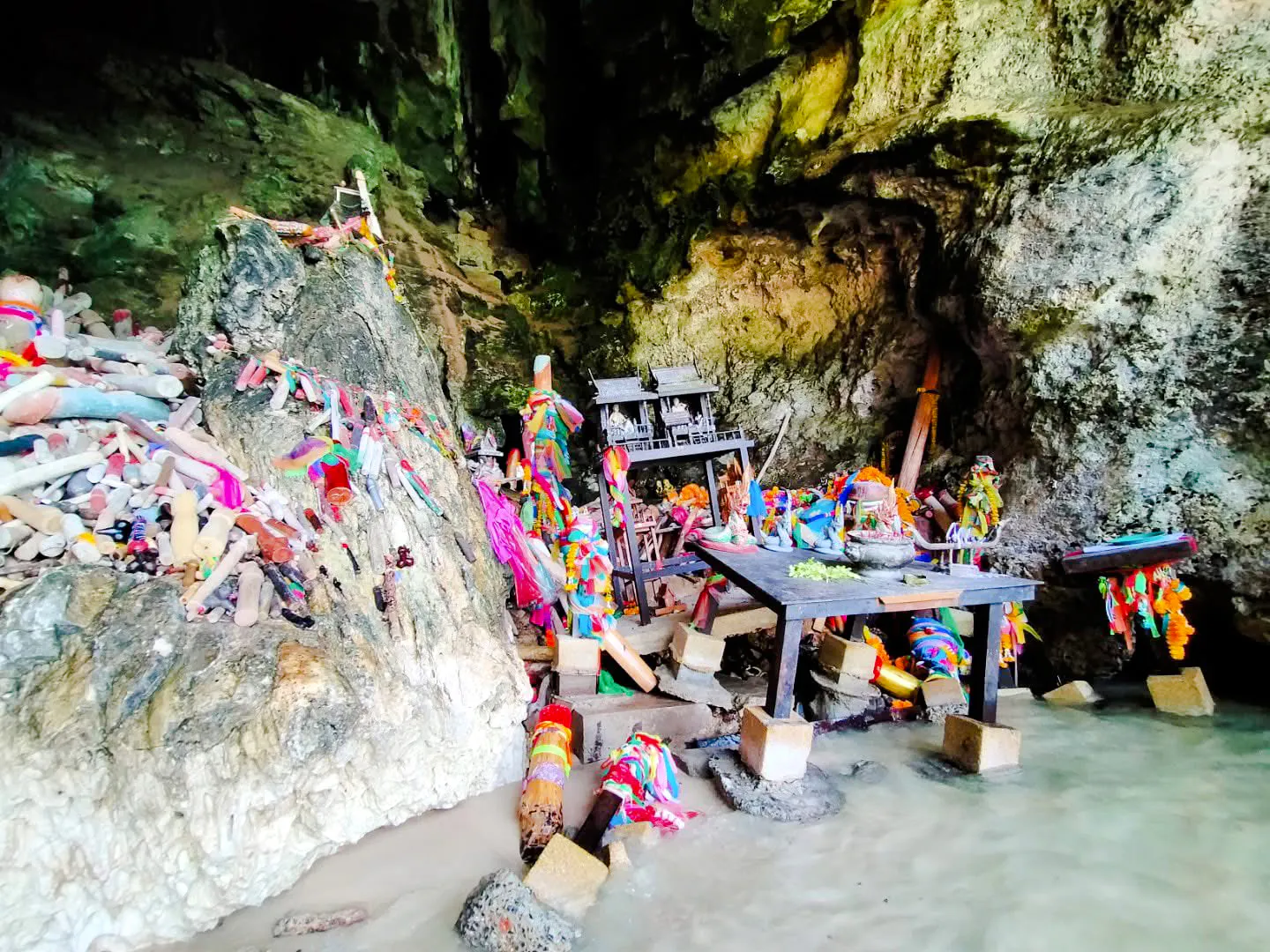 Shrine with colorful offerings inside a cave on the Krabi 4 Islands tour.