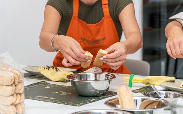 Hands preparing ingredients during a pasta making class.