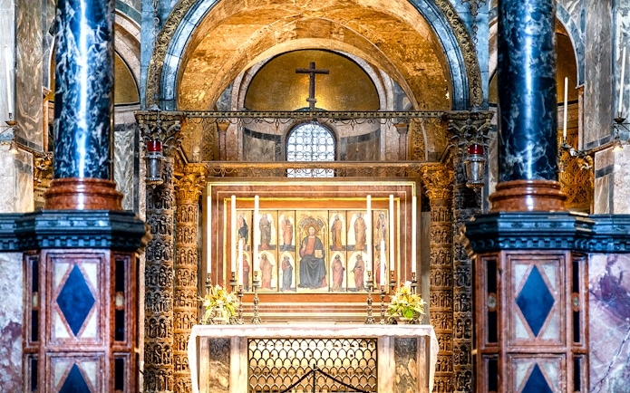 Interior of St. Mark’s Basilica altar with ornate columns and religious artwork, Venice.