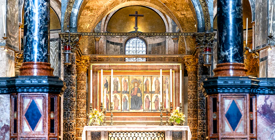 Interior of St. Mark’s Basilica altar with ornate columns and religious artwork, Venice.