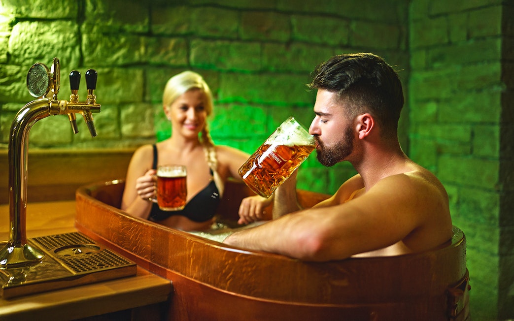 Man enjoying beer in a wooden tub at Prague Spa Beerland.