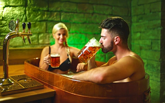 Man enjoying beer in a wooden tub at Prague Spa Beerland.
