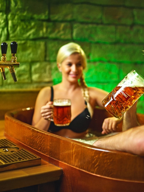 Man enjoying beer in a wooden tub at Prague Spa Beerland.