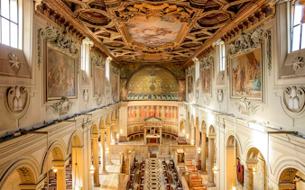 Basilica of San Clemente interior with ornate ceiling and frescoes, Rome.