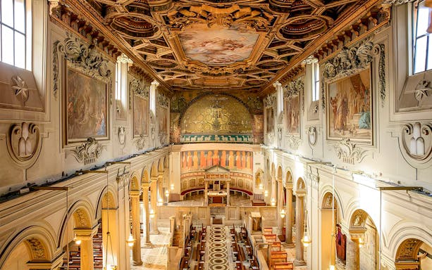 Basilica of San Clemente interior with ornate ceiling and frescoes, Rome.