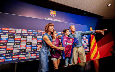 Family posing with FC Barcelona jersey at Camp Nou press room.