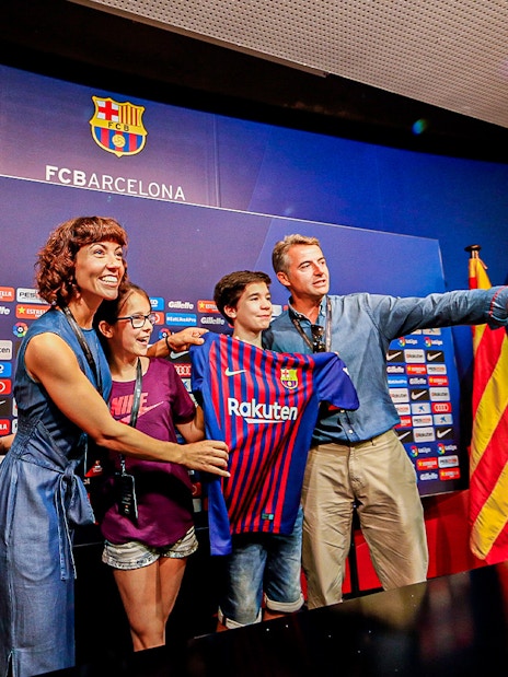 Family posing with FC Barcelona jersey at Camp Nou press room.