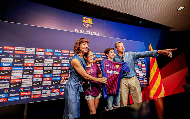 Family posing with FC Barcelona jersey at Camp Nou press room.