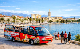 Sightseeing bus near Split waterfront with Diocletian's Palace in the background.