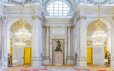 Royal Palace of Madrid interior with grand chandeliers and statues, part of a combo tour with Royal Collections Gallery.