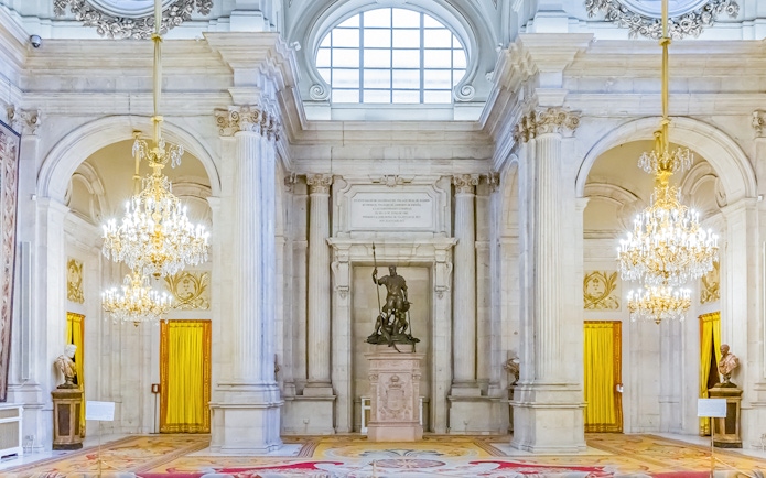 Royal Palace of Madrid interior with grand chandeliers and statues, part of a combo tour with Royal Collections Gallery.