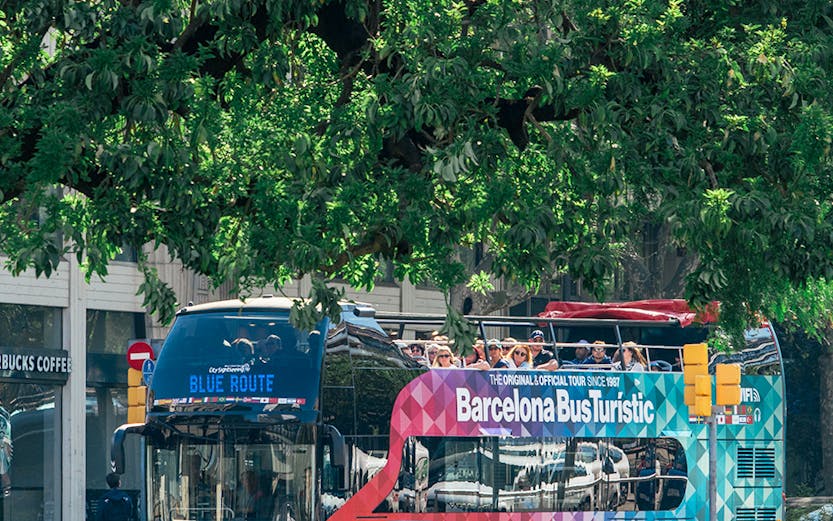 Barcelona Bus Turistic double-decker on city street, offering hop-on hop-off tour.